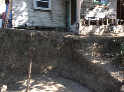 When soil on top of the concrete garage roof, downslope of the house, was excavated, the garage roof was found to be in need of repair to restore effective drainage and waterproofing.