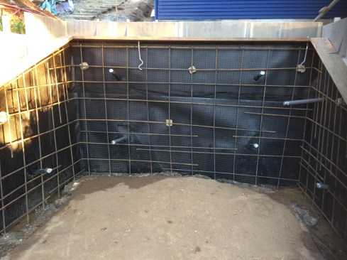 To prepare for the application of shotcrete, the crew assembled a light-gauge-steel one-sided form with a cementitious panel face, applying MiraDrain drain board to the form faces and installing a 12-inch grid of rebar.
