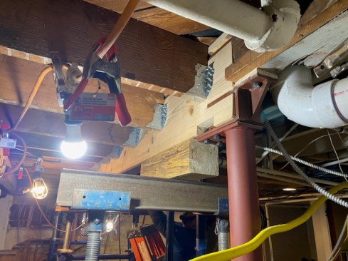 When joists have been notched to sit on a ledger that is replaced with a load-carrying beam, the author begins by infilling the notch in the joists with a block of wood, as shown at left). He then will installs Simpson HTU hangers, which have an elongated heel made for trusses.