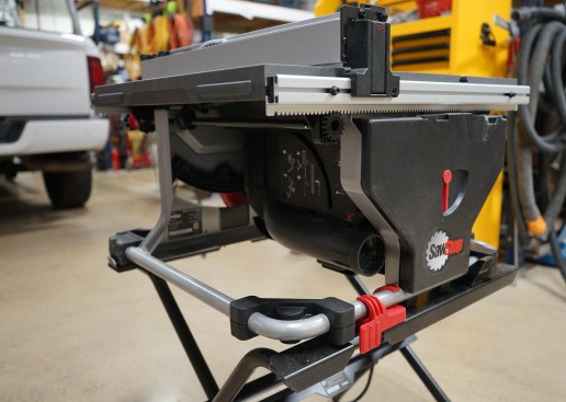 The rack-and-pinion fence on the CTS reliably holds the fence square to the blade. The red quick release (in foreground; there is another on the front of the saw diagonally opposite this one) secures the saw housing to the folding stand (available as an added accessory). Note, too, the 2 1/2-inch dust collection port, which pulls from directly under the blade. This configuration noticeably collects dust better than many other compact table saws.