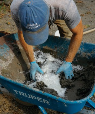 He adds a water-reducing admixture to make the mix more workable, then mixes in fiberglass reinforcing filaments.