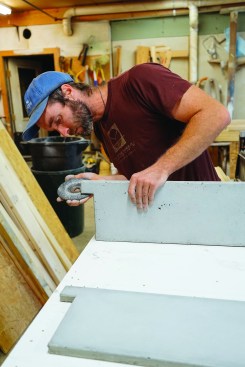 After a few days, he strips the forms and finishes the surface, starting by rubbing off rough spots with a grinding disk.