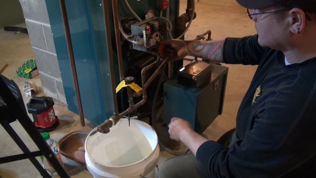 ReVision Energy master plumber Dan Leonard cuts a water line serving the existing boiler.