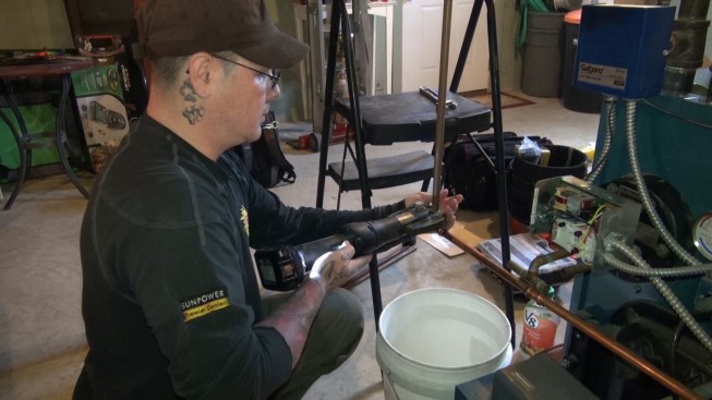 Then he patches in the water line for topping up the boiler’s hydronic loops using a solderless compression fitting.