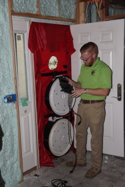 Technician Jack Hogan zeros the electronic manometer before the blower-door test.