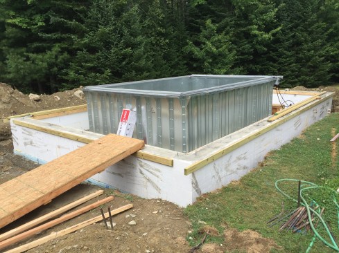 The galvanized-steel pool-panel sections bolt together.