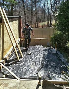 We created a gentle slope to the soil and a swale to carry away any ground water or rain away from the deck frame. Then we covered the soil with heavy landscaping cloth and some stone.