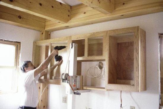 One-person installation is possible with a cabinet lift like this older-model Cabinetizer (telproproducts.com).