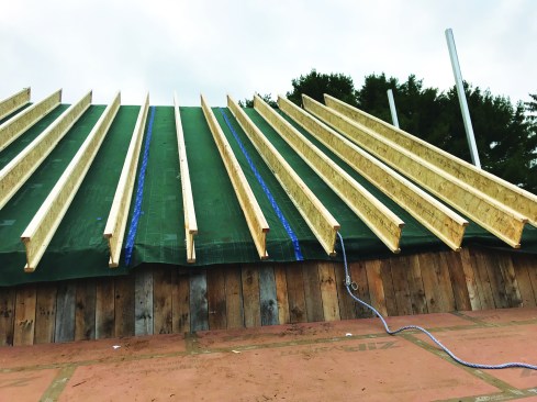 Then they built up a wood I-joist roof on top of the existing barnboards starting with a layer of felt paper to prevent the green Pro Clima DA air barrier membrane from telegraphing through the gaps between boards.