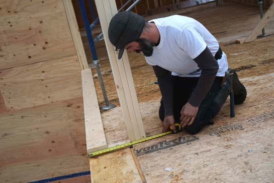 Carpenters mark, measure, cut, and place 20-inch LVL members as they assemble a high-capacity engineered wood structure in place, piece by piece.