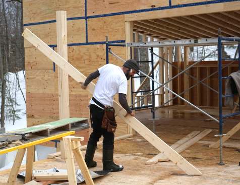 Carpenters mark, measure, cut, and place 20-inch LVL members as they assemble a high-capacity engineered wood structure in place, piece by piece.