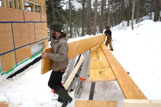 Carpenters mark, measure, cut, and place 20-inch LVL members as they assemble a high-capacity engineered wood structure in place, piece by piece.