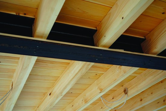 After nailing down tongue-and-groove ceiling boards topped by AdvanTech subflooring, the crew locked the joists in from below with pan-head screws.