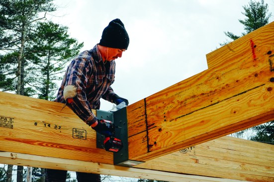 Once in place, the beam is secured to the hanger with screws.