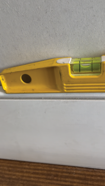 With the baseboard set level, tack the baseboard in place to prepare to scribe. 