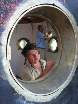 Large marine portholes were salvaged from a decommissioned ship and installed in the room just below the light to provide light, air, and mind-boggling views.