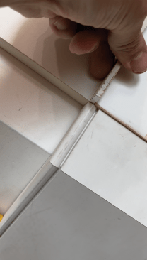 Baseboard can be scribed to fit the floor using a scrap of wood cut to the thickness that the baseboard needs to drop.