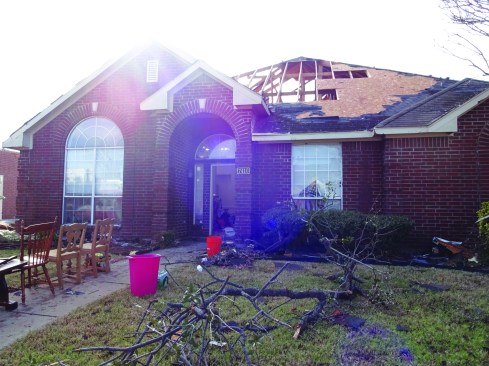 Roof sheathing has been ripped away from trusses.