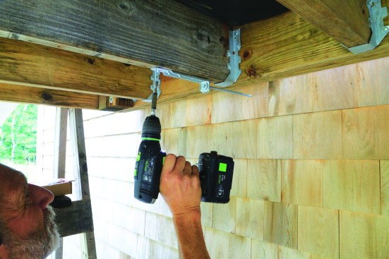 The IRC 4x750-lb. lateral-load detail is well suited for retrofits, since it doesn’t require access to the house interior; here, an SST DTT1 tie connected to a 3/8-inch lag screw embedded at least 3 inches into house framing is being fastened to the bottom of a deck joist.
