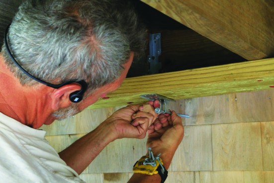 The lateral-load hardware—FastenMaster LTS in this case—can then be accurately positioned for the 3/8-inch lag screws to penetrate the studs.