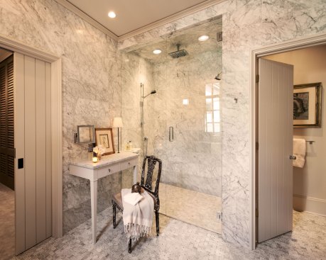 The larger, more open shower has become the focal point of the master bathroom. It boasts a thermostatic control valve, a normal shower head, a rain head, and a hand-held sprayer along with a remote sound system.