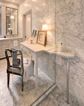 The dressing table counter slices through the shower glass to become a shelf with a scalloped soap dish and grooved drains along the edge.