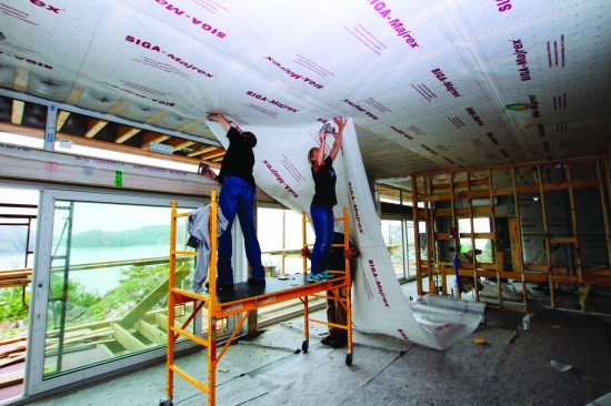 The crew stapled up directional vapor barrier material after the cavities were blown with insulation.
