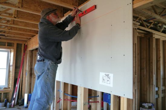 A level layout line marks the location for the bracket on which the minisplit’s indoor head unit will hang. Before the drywall was installed, blocking was added to the wall framing for support. 