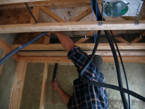 The insulated line-set tubing is fed through holes in the top plates on its way down the sidewall and eventually to the exterior of the house.