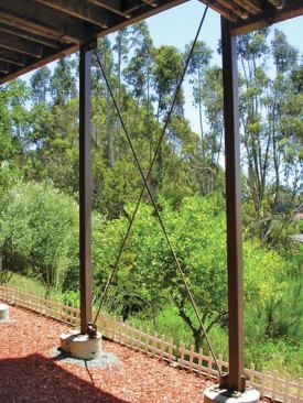 The moment frame is diagonally braced with 1-inch-diameter threaded rod, which is bolted to brackets welded to the steel columns.