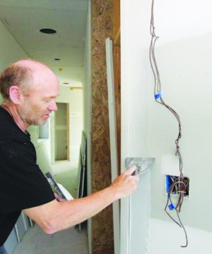 Then he uses a 6-inch drywall knife to apply the first of three coats of compound to smooth out the acute joint.