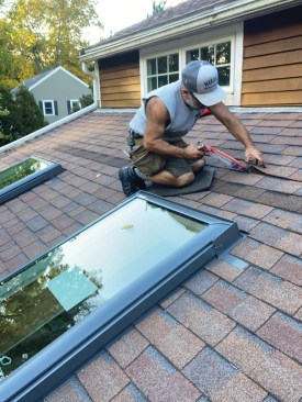 Whenever I reinstall shingles, I always apply dabs of sealant to the tabs to ensure that the overlapping shingles will adhere to the ones underneath. Note the foam rubber pad that I’m kneeling on in many of the photos; years ago, I cut a number of pads from 24-by-24‑inch interlocking floor tiles and have used them on an almost daily basis ever since to protect my knees from stones, splinters, nail heads, and—in this case—the coarse granules of the asphalt shingles.