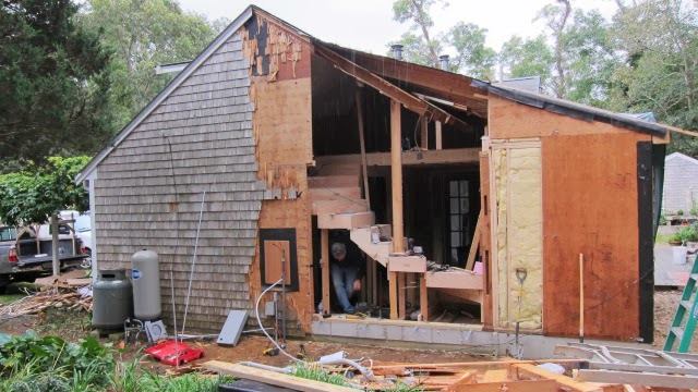 The exterior wall was removed to accommodate four, two-story high engineered posts needed for bracing around a new, stepped window array. The full-height second floor was added later.