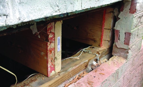 The mason had to remove four courses of brick to expose the entire rim joist, which was cut back until only undamaged wood was exposed.