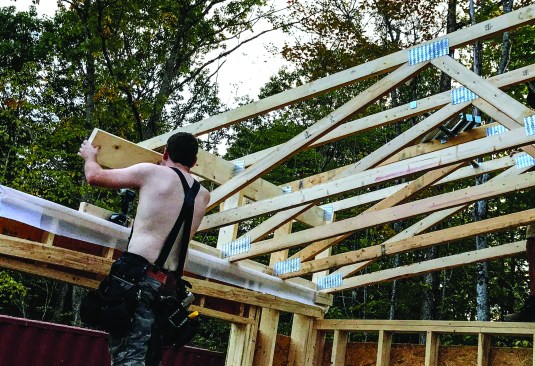 The monopitch truss roof assembly was one of the more labor-efficient and cost-effective aspects of the project, said Dwyer. Here, Dwyer installs blocking as the crew sets trusses.