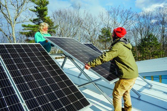 Above, David Kelly and carpenter Sonny Searles set photovoltaic modules for the home's solar power array. The PV system is intended to match the building's projected annual power requirement, but may be slightly over-sized, said Kelly.