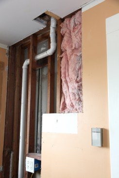 The vent pipe from the T-Wye enters the adjacent stud bay and then is routed through the ceiling next to one of the ceiling joists. Once above the loft floor over the kitchen, the vent diameter increases to 2 inches, the minimum legal size for an auxiliary vent where it penetrates the roof.