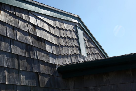 Instead of having the siding cut at an angle, the carpenter stepped the shingles up the roof plane, probably due to lack of a quick and easy way to cut the shingles without electricity.