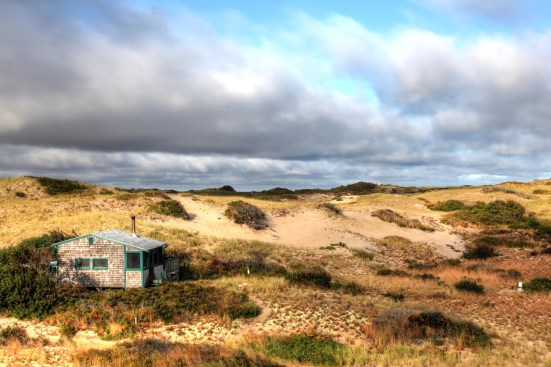 This view looking southwest shows the proximity of the pump (covered with a white bucket at the extreme right), to the shack. Filled containers had to be carried up the grade to the shack.