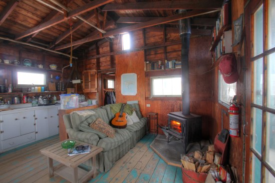 The main volume of the shack houses the living and dining areas along with the kitchen. The woodstove provides heat.