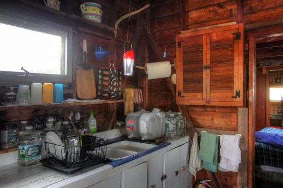 The kitchen sink sits at the other end of a hodge-podge of base cabinets. With no indoor water supply, the sink is just connected to a drain into a cistern.