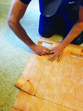 Similarly, the sides are cut downward (toward the knees in this photo) to create flaps that will lap onto the base, or “floor,” of the inset.
