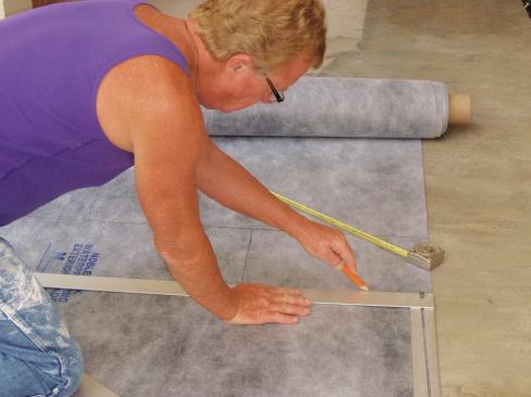 Plot out the dimensions of the patio and transfer them to the membrane, curl facing down (unlike what is shown in the photo). Use a 3-4-5 folding square and a marker.