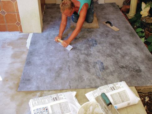 Once the entire sheet is adhered, embed the membrane firmly in the thinset using a magnesium float. Push excess mortar to the edge of the sheet.