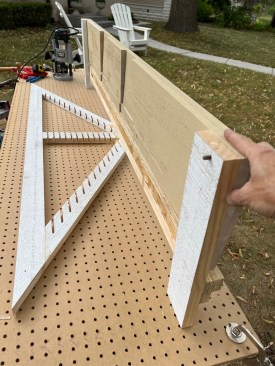 The author builds a jig that bridges across the top of a frame for a gable-end vent. Shelf pins in the jig register in the holes on the pegboard work surface.
