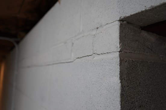 The tell-tale cracks in a CMU wall that has bulged inward from hydrostatic pressure pushing against the foundation from the exterior.