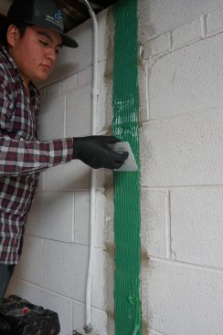 A helper spreads the epoxy out.