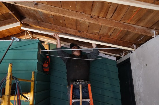 Toby Bonilla installs 2x6 sisters to the existing 2x4 rafters.