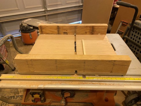 The author uses a table-saw sled with a cleat fixed to the plywood that’s the same width as the dado. The cleat is placed at the distance between successive dado cuts (in this case about 4 inches for an adjustable shelf system).