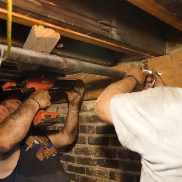 Toby and his brother Ernesto  inject epoxy, and set the threaded rod. 